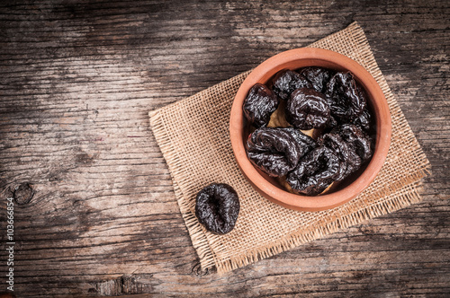 Dried plums in clay bowl 