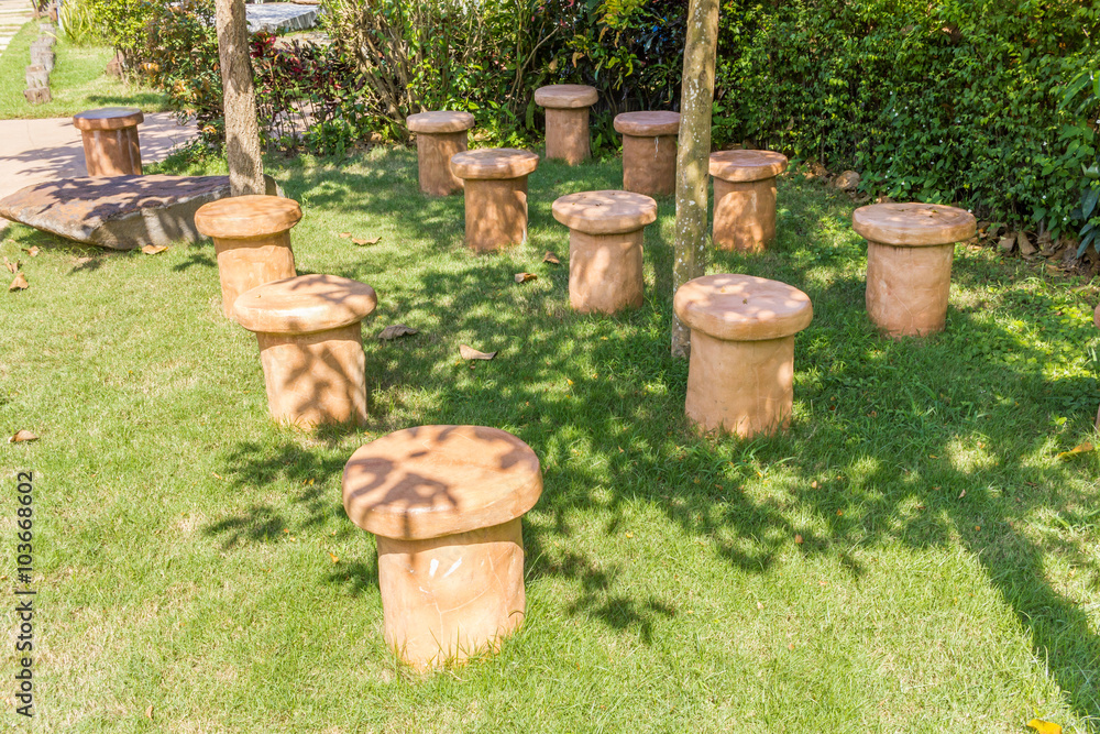 Fototapeta premium concrete stools with trees and grass floor in garden 
