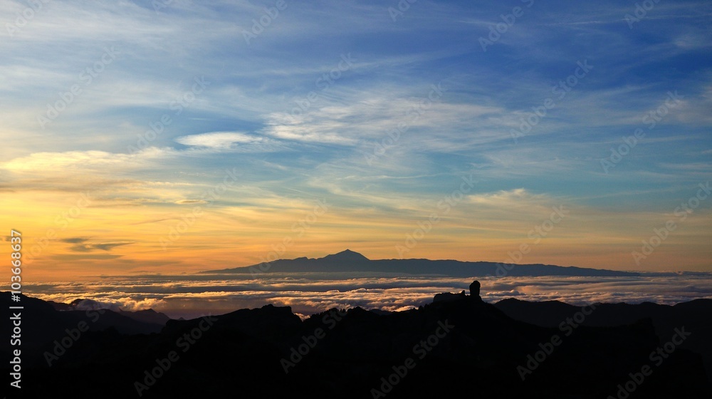 Vibrant sunset with Roque Nublo in foreground and Tenerife island in background, Canary islands 