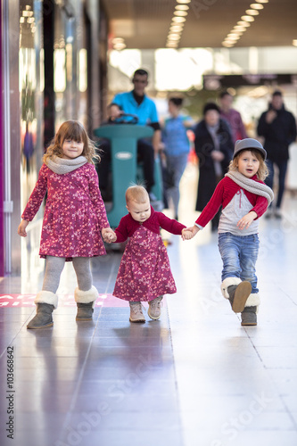 Girls sister walk along the mall, playing in  big store, © natalialeb
