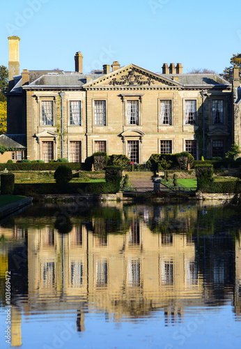 A photograph of Coombe Abbey hotel and its reflection in the waters of the grounds. photo
