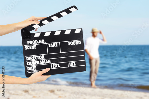 Operator holding clapperboard during the production of film outdoor