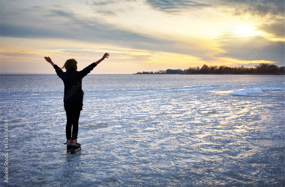 Girl on roller skates standing on a frozen lake 