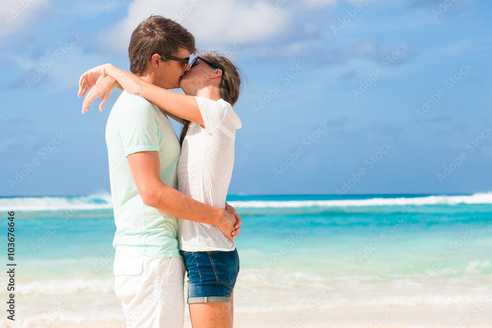 back view of happy young couple hugging on the beach back view of happy young couple hugging on the beach