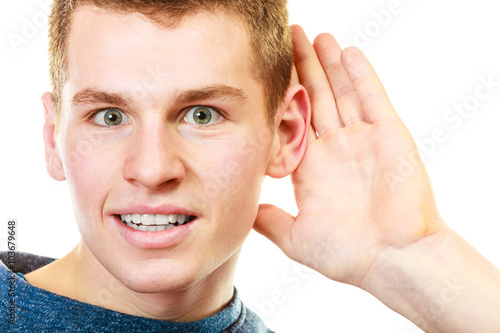 Obraz na plátně gossip boy with hand behind ear spying