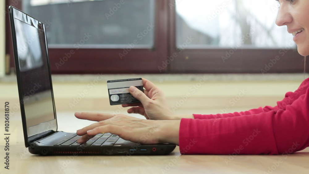 Happy young woman lying on floor with laptop computer and credit card at home, close up
Happy young woman lying on floor with laptop computer and credit card at home, close up