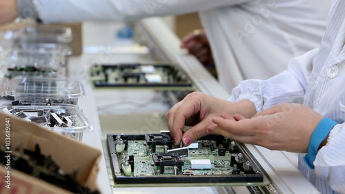 Workers are manufacturing Circuit Boards in Electronics Factory - Assembly line of LEDs, Transistors and other Electronic components being installed