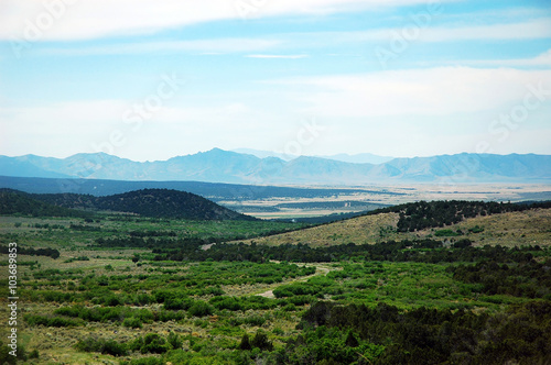 spring plain with forest, hill and remote mountains