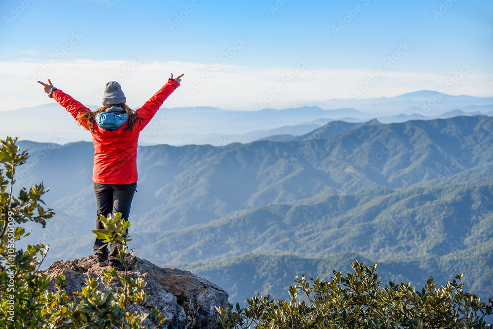 Woman traveler on peak of mountain