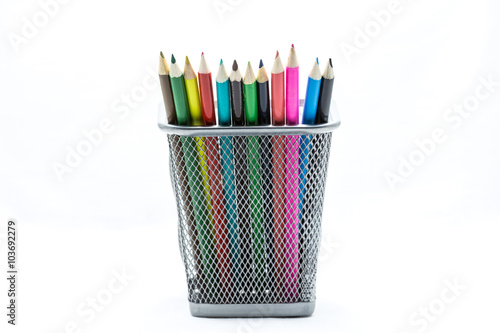 Colored crayons on the basket isolate on white background