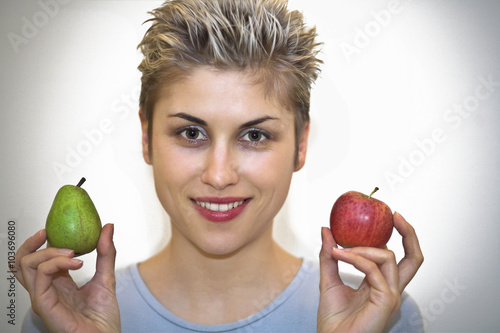 woman hesitating : holding a pear and an apple