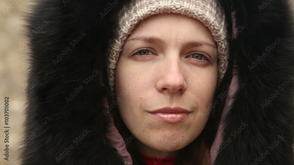 young girl in winter clothes chews the cud, outdoors young girl in winter clothes chews the cud, outdoors