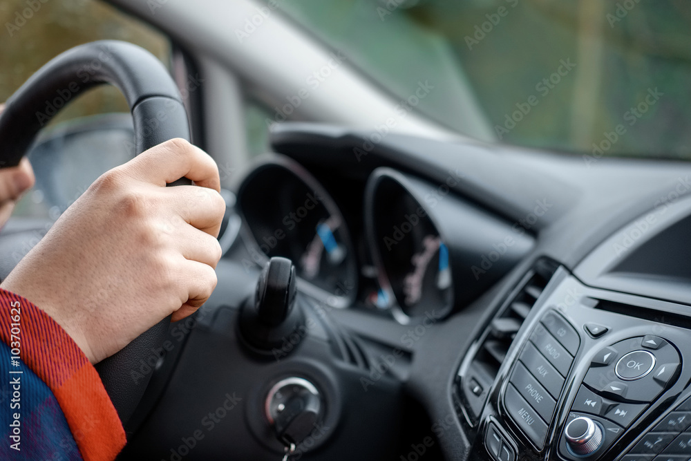 hands of man driving the car and holding wheel