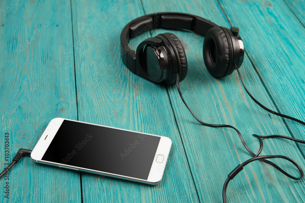 phablet and headphones on the wooden desk phablet and headphones on the wooden desk