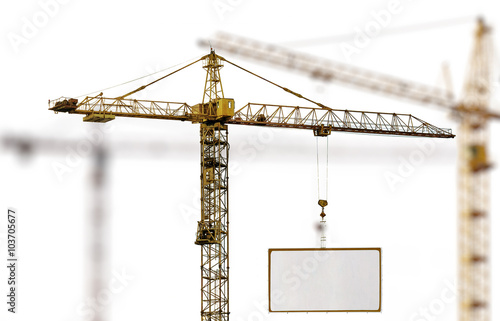 yellow hoisting crane with advertisement hoardin