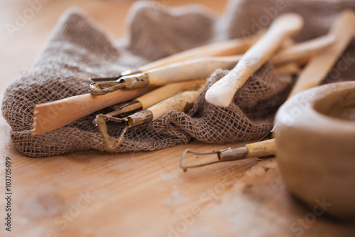 Set of dirty craft sculpting tools in pottery workshop photo