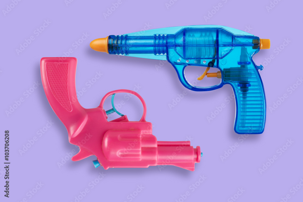 Two water pistols isolated on violet background Two water pistols isolated on violet background