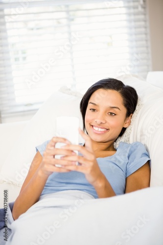 Smiling brunette using smartphone