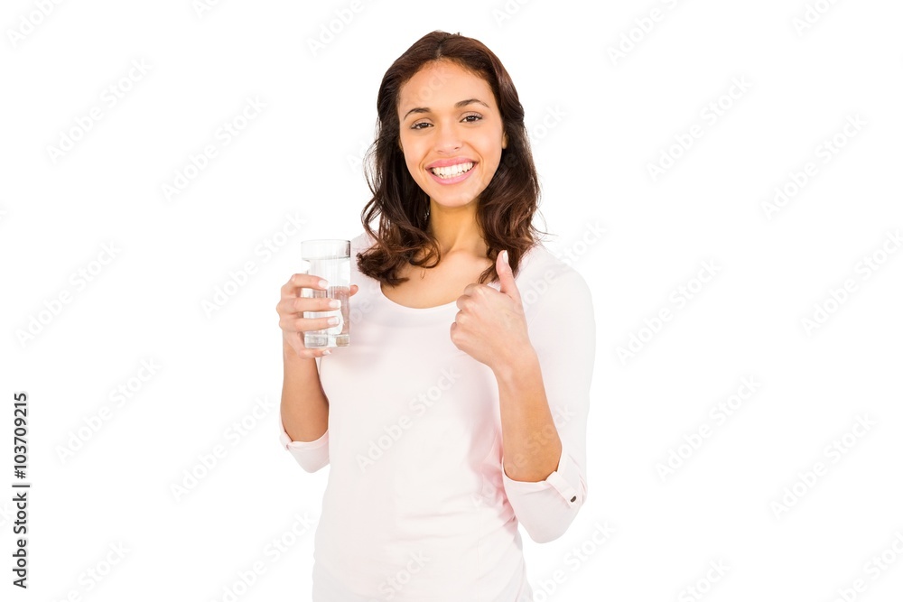 Smiling woman with thumbs up holding glass of water Smiling woman with thumbs up holding glass of water