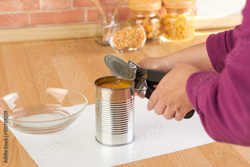 Fotografía woman opening a can of corn with can opener