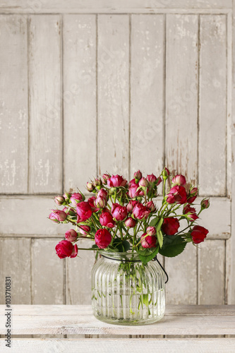 Bouquet of red roses on wooden background