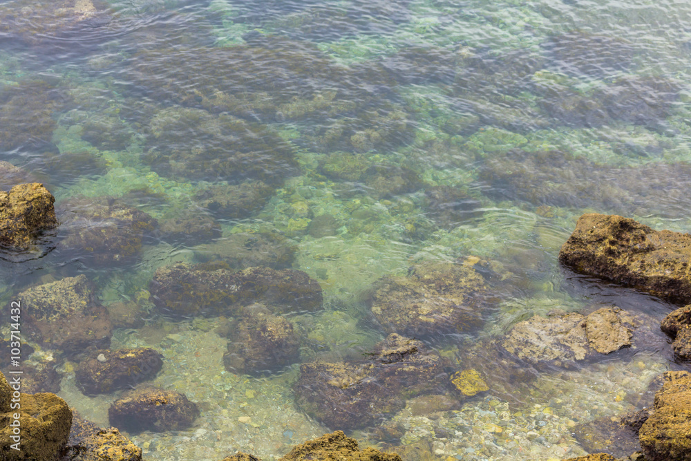 Background with crystal clear water and small waves and rocks Background with crystal clear water and small waves and rocks