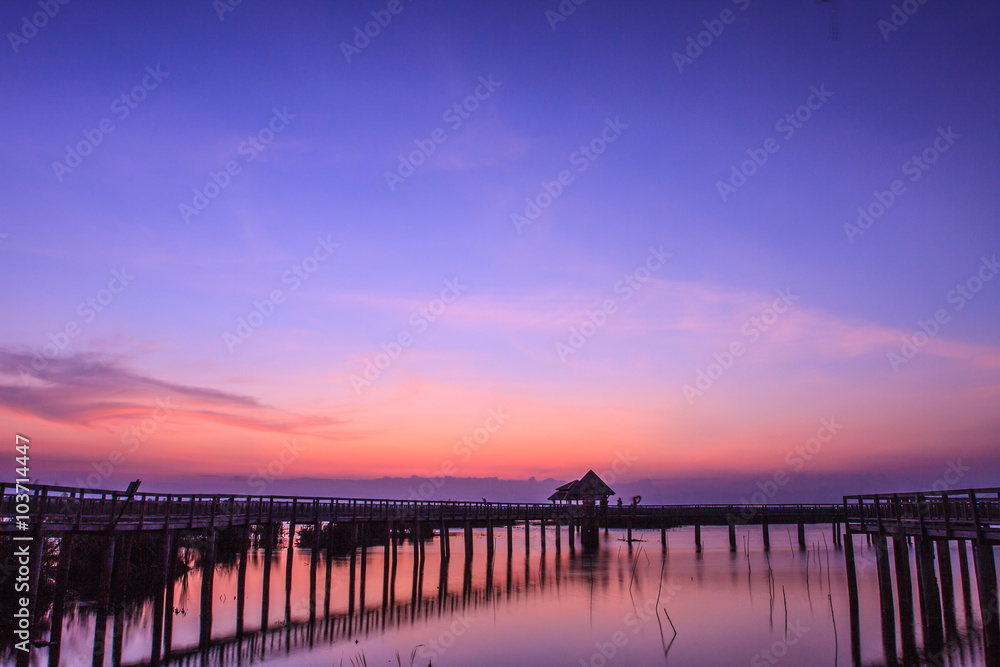 Fototapeta premium Wooden Bridge in lotus lake on sunset time