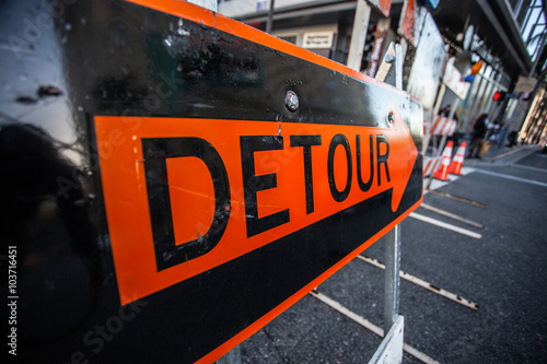 Big orange sign Detour in the middle of the street