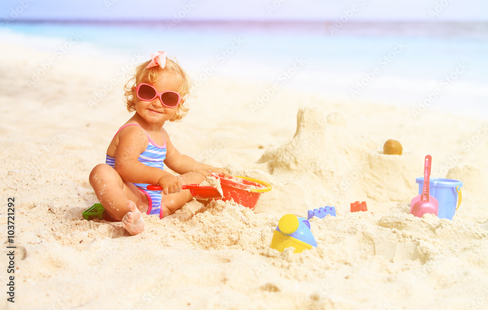 cute little girl playing with sand on beach cute little girl playing with sand on beach