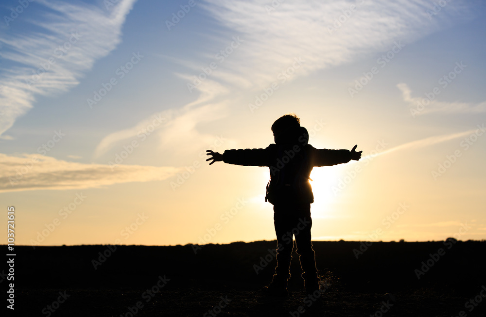 Silhouette of happy little boy travel at sunset