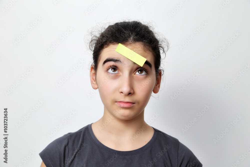 Fototapeta premium Little girl with memo posts on her forehead