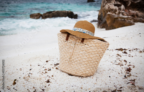 Straw hat and bag on a tropical beach