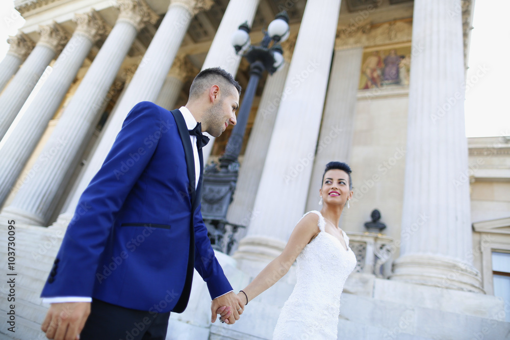 Beautiful bridal couple embracing near columns Beautiful bridal couple embracing near columns