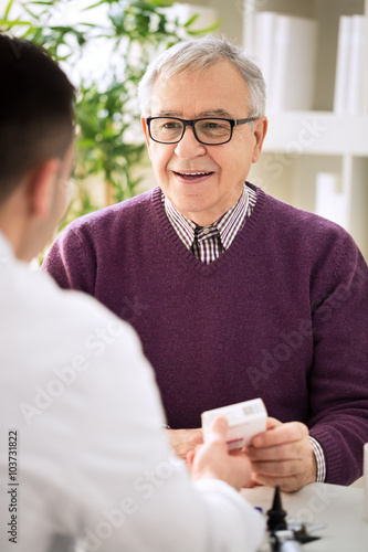 Medical doctor consulting senior patient