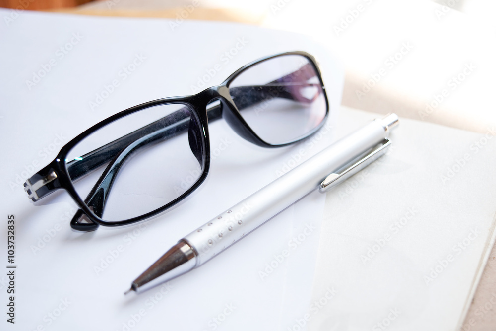 Glasses and pen on notebook - Soft light style Glasses and pen on notebook - Soft light style