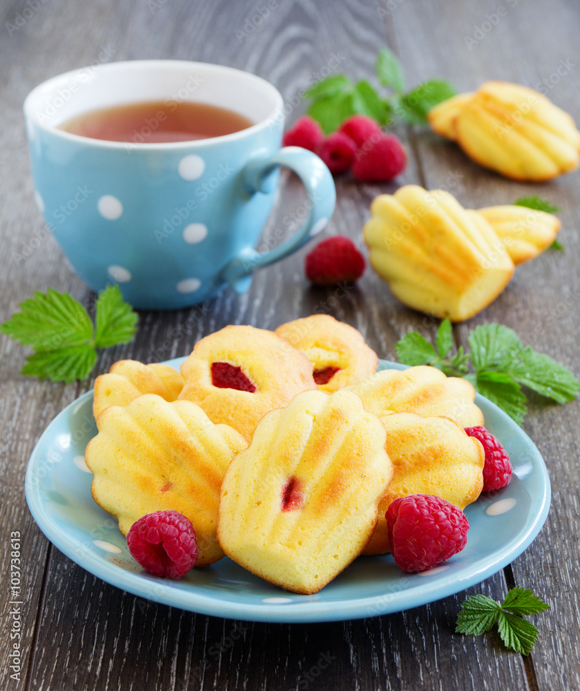 French pastries madeleines with raspberries. French pastries madeleines with raspberries.