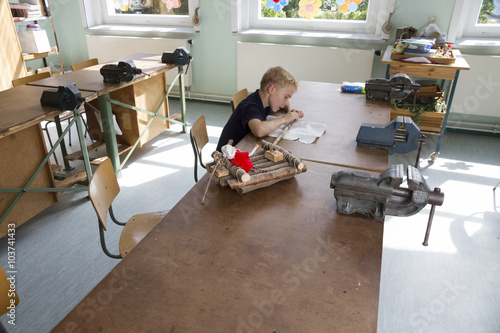 Little boy is working for a boat. 