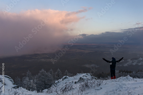 A man on a hill opposed to cloud