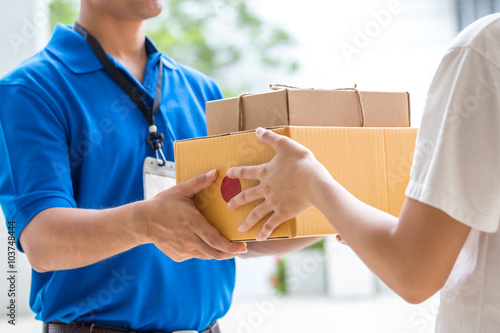Woman hand accepting a delivery of boxes from deliveryman photo