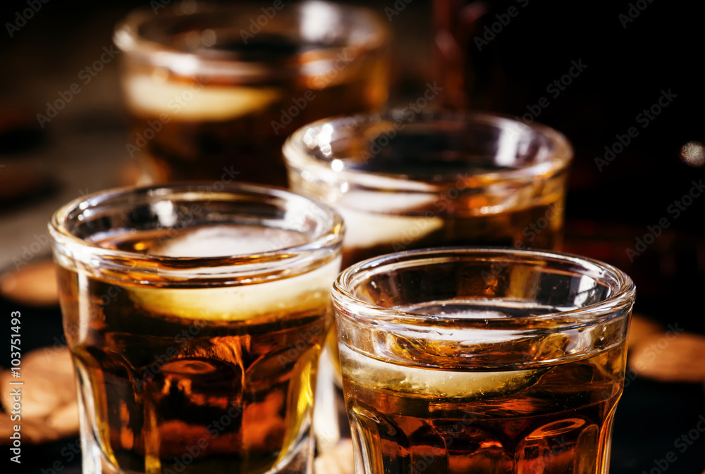 Brandy and almonds, small glasses on a dark background, selectiv Brandy and almonds, small glasses on a dark background, selectiv