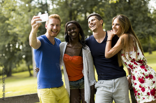 Young multiracial friends taking selfie in the park