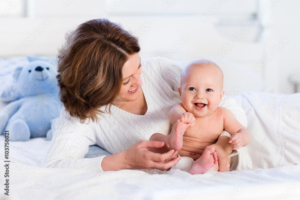 Mother and baby on a white bed Mother and baby on a white bed