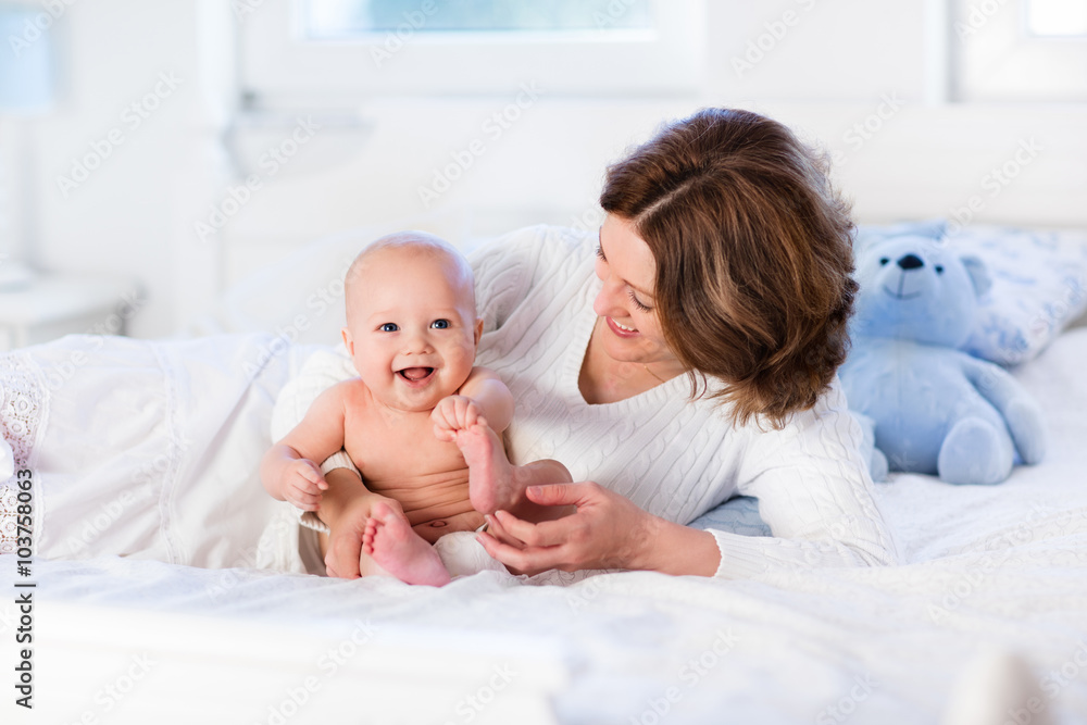 Mother and baby on a white bed Mother and baby on a white bed