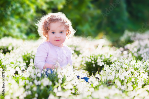 Little girl in sunny flower field