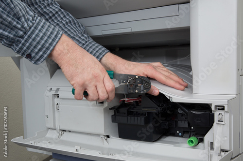 Side view of businessman adjusting cartridge in photocopy machine © OceanProd