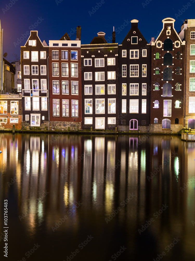 Buildings along the Damrak at Night in Amsterdam