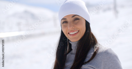 Cuadro en lienzo Gorgeous young woman in winter fashion in a snowy landscape looking at the camer