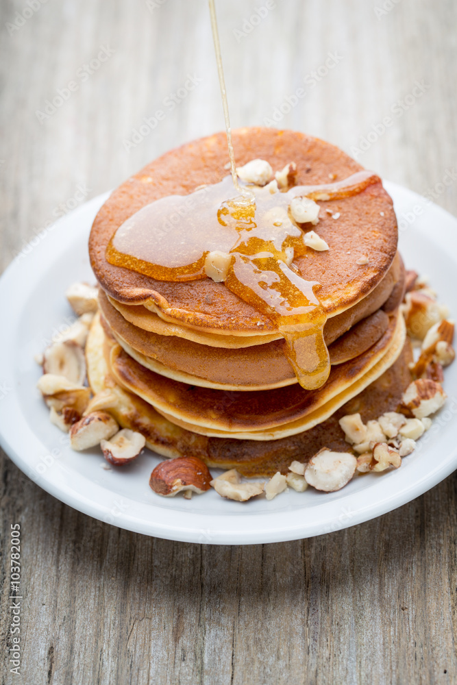 Stack of homemade pancakes with honey on wooden background. Stack of homemade pancakes with honey on wooden background.