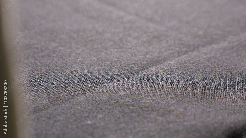 Designer at work taking scissors to cut piece of black cloth