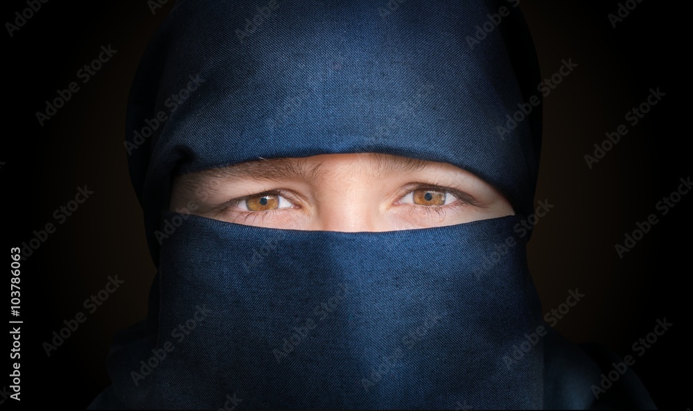 Eyes of young woman veiled with blue niqab scarf. Low key photo. Eyes of young woman veiled with blue niqab scarf. Low key photo.